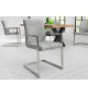 Chaise design tissu gris pierre avec accoudoirs et armature en acier